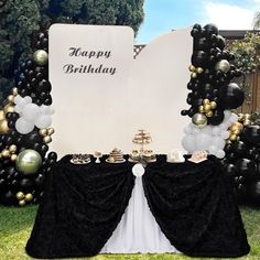 a black and white birthday party with balloons, cake and desserts on the table