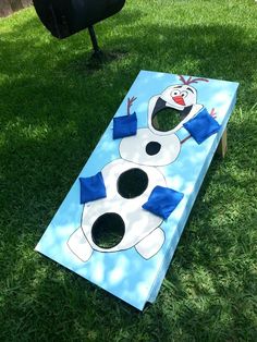 this is an image of a frozen world cornhole board game on the grass with snowman