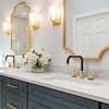 a bathroom with two sinks, mirrors and lights on the wall above them is shown