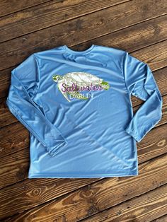 Our long sleeve fishing shirts are not only comfy but cooling for those hot summer days. Our fishing shirt offers 44+ UPF for sun protection too!  What better way to stay safe and cool in the sun while you look cute too?!? Front Saltwater Darlin logo and back design on light blue long sleeve. These designs are my own original design transferred to tee and hold up excellently!  100% polyester unless otherwise noted. Stain release and odor resistant. Moisture wicking too!  Care instructions:  Wash Casual Long Sleeve Tops For Water Sports, Casual Crew Neck Rash Guard For Water Sports, Casual Long Sleeve Rash Guard With Upf 50+, Casual Rash Guard With Upf 50+ For Outdoor Activities, Casual Long Sleeve Blue Rash Guard, Long Sleeve Rash Guard With Upf 50+ For Spring, Long Sleeve Moisture-wicking Rash Guard For Summer, Moisture-wicking Long Sleeve Rash Guard For Summer, Summer Long Sleeve Moisture-wicking Rash Guard