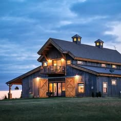 a large barn with lights on the windows