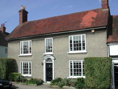 an old house with white windows and red roof