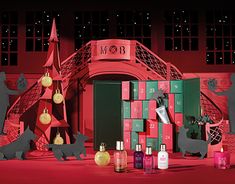 an assortment of beauty products on display in front of a red building with christmas decorations