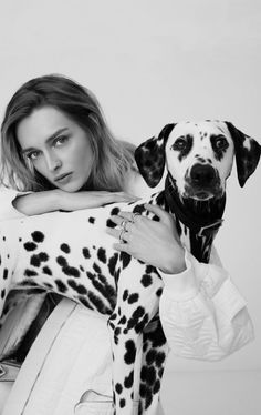 a woman is holding a dalmatian dog in her arms and posing for the camera