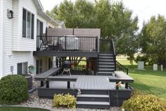 a deck with steps leading up to the upper level and an outdoor grill on the second floor