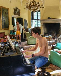 a young man sitting at a piano in a living room