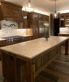 a kitchen with an island in the middle of it and wooden cabinets on both sides