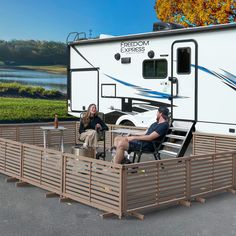 a man and woman sitting in front of an rv