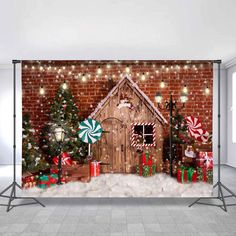 a christmas scene with a gingerbread house and candy canes in front of a brick wall