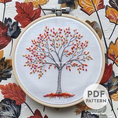 an embroidered tree with autumn leaves on it