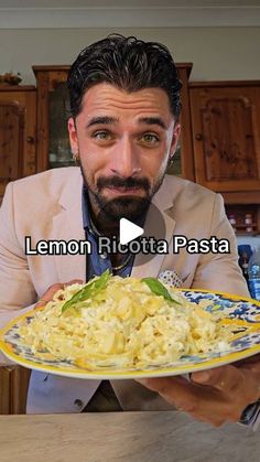 a man holding a plate of pasta with lemon ri rota pasita on it