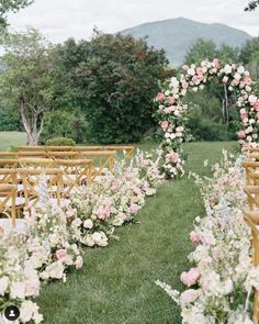 an outdoor ceremony set up with wooden chairs and flowers