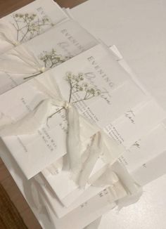 several pieces of white paper tied together with ribbons