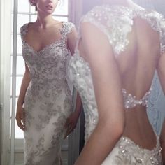 a woman in a wedding dress looking at herself in the mirror