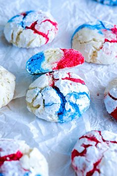 red, white and blue cookies are sitting on wax paper