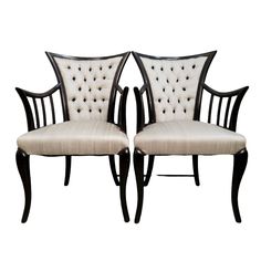 a pair of chairs with white upholstered cushions