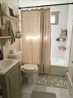 a bathroom with a toilet, sink and shower curtain in it's stall area