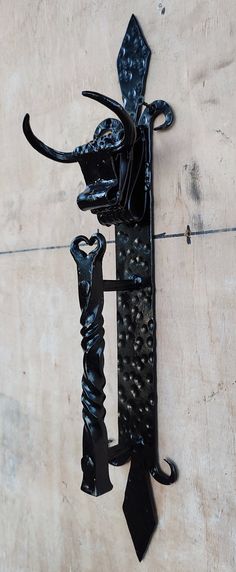 a black tie hanging from the side of a wall next to a hook on a door