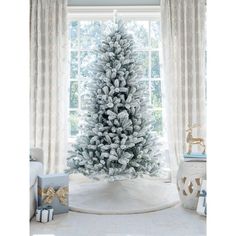 a white christmas tree in front of a window