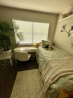 a bedroom with a bed, desk and chair next to a window in the corner