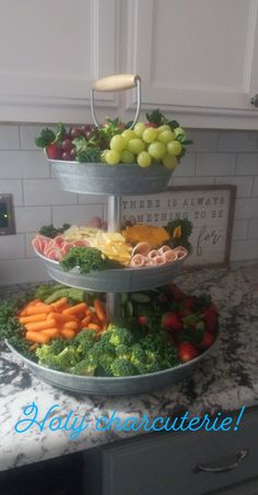 three tiered platter filled with fruits and vegetables