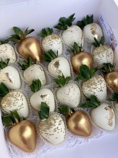 chocolate covered strawberries in a white box with green leaves on the top and gold decorations