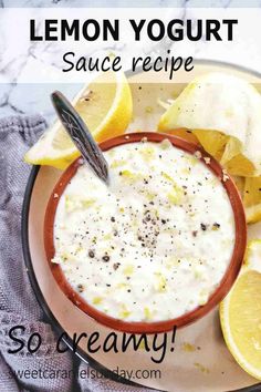 lemon yogurt sauce recipe in a bowl with sliced lemons on the side