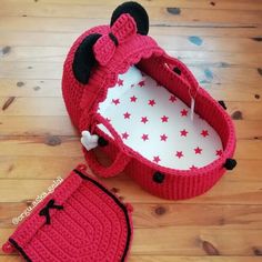 a crocheted mickey mouse hat and diaper cover on a wooden floor next to it