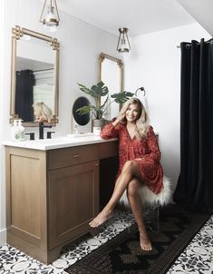 a woman sitting on a vanity in a bathroom