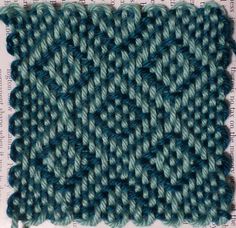 a close up view of a knitted piece of cloth with blue and green yarn