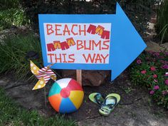 a sign that says beach bums this way with flip flops on the ground