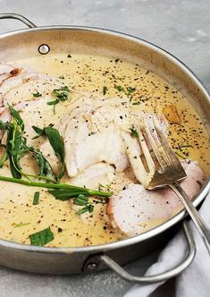 a pan filled with chicken and garnish on top of a white table cloth