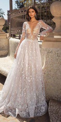 a woman in a wedding dress standing on a stone wall