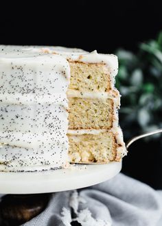 a cake with white frosting and black sprinkles on it is sitting on a plate