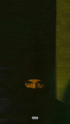 a person wearing a black hood with their face obscured by the shadow of a wall