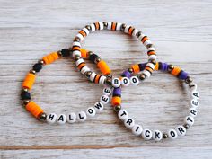 two bracelets that say halloween and one has the word boo on it, both decorated with beads