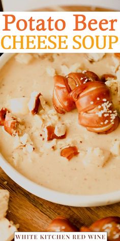 a bowl of potato beer cheese soup on a wooden table with crackers and tomatoes