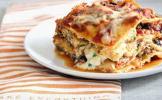 a white plate topped with lasagna casserole on top of a table