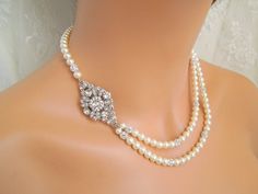 "This pearl necklace is created with a vintage look embellishment and Austrian pearls in cream color. Focal point is embellished with various sizes of Austrian chatons crystals.  Inner strand measures approximately 17\" long.  Necklace comes with 2\" extender chain for additional length. Pearls measure 6 mm and are accented with rhinestone balls for a glamorous look!   Finished off with a filigree attached to a lobster claw closure.  Focal point measures approximately 1 3/4\" by 1\" wide.  What a romantic piece for any bride! Austrian elements used: 6 mm cream pearls.  Embellishment has some Austrian crystals and rhinestones. Coordinating Earrings, https://www.etsy.com/listing/97637197/bridal-earringspearl-rhinestone?ga_search_query=colleen https://www.etsy.com/listing/92717554/clip-on-ear Elegant Cream Pearl Necklace For Wedding, Elegant Pearl Necklace With Rhinestones For Wedding, Pearl White Bridal Necklace For Mother Of The Bride, Classic Crystal Pearl Necklace For Wedding, Pearl White Bridal Necklace With Pearl Charm For Wedding, Cream Pearl-embellished Jewelry For Wedding, Cream Pearl Embellished Jewelry For Wedding, Cream Pearl Drop Necklace For Wedding, Cream Pearl Bridal Necklace For Wedding