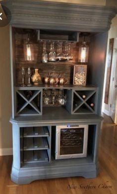 a blue hutch with wine glasses on the top and an open shelf above it