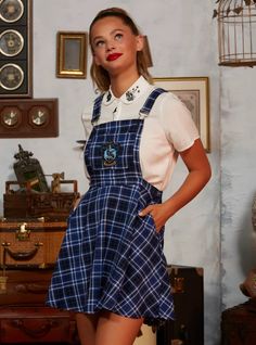 a woman in a blue and white dress posing for the camera with her hands on her hips