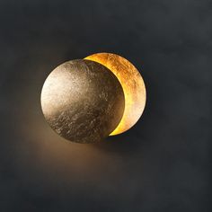 two yellow and black moon lights against a dark background with only one light on the side