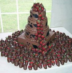 a chocolate cake with strawberries on top and other decorations around it in the shape of a tower