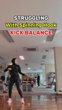 a woman standing on top of a hard wood floor next to a gym equipment rack