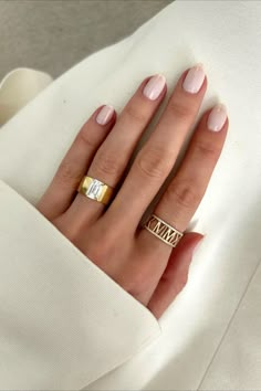 a woman's hand with two gold rings on it