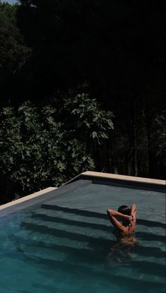 a man laying in the middle of a swimming pool