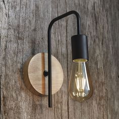 a light that is on the wall next to a wooden object with a black handle