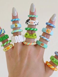 a woman's hand with many different rings on it, including an elephant and giraffe