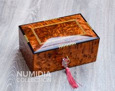 a small wooden box with a tassel on top