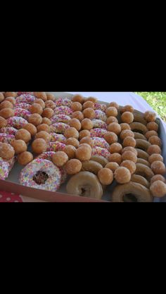 a box filled with lots of donuts covered in sprinkles on top of a table